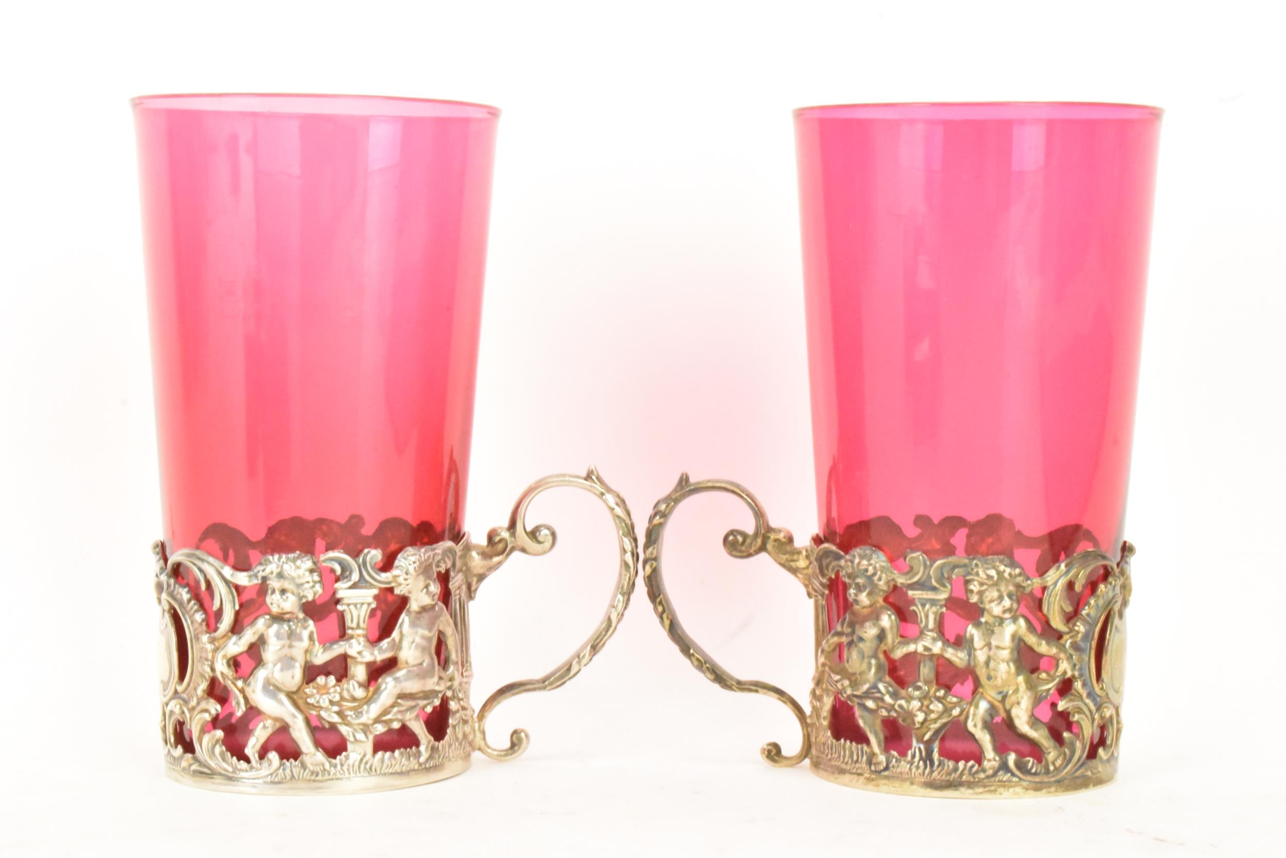 A pair of Edwardian silver glass holders with a pair of cranberry glasses, the holders ornately - Image 3 of 6