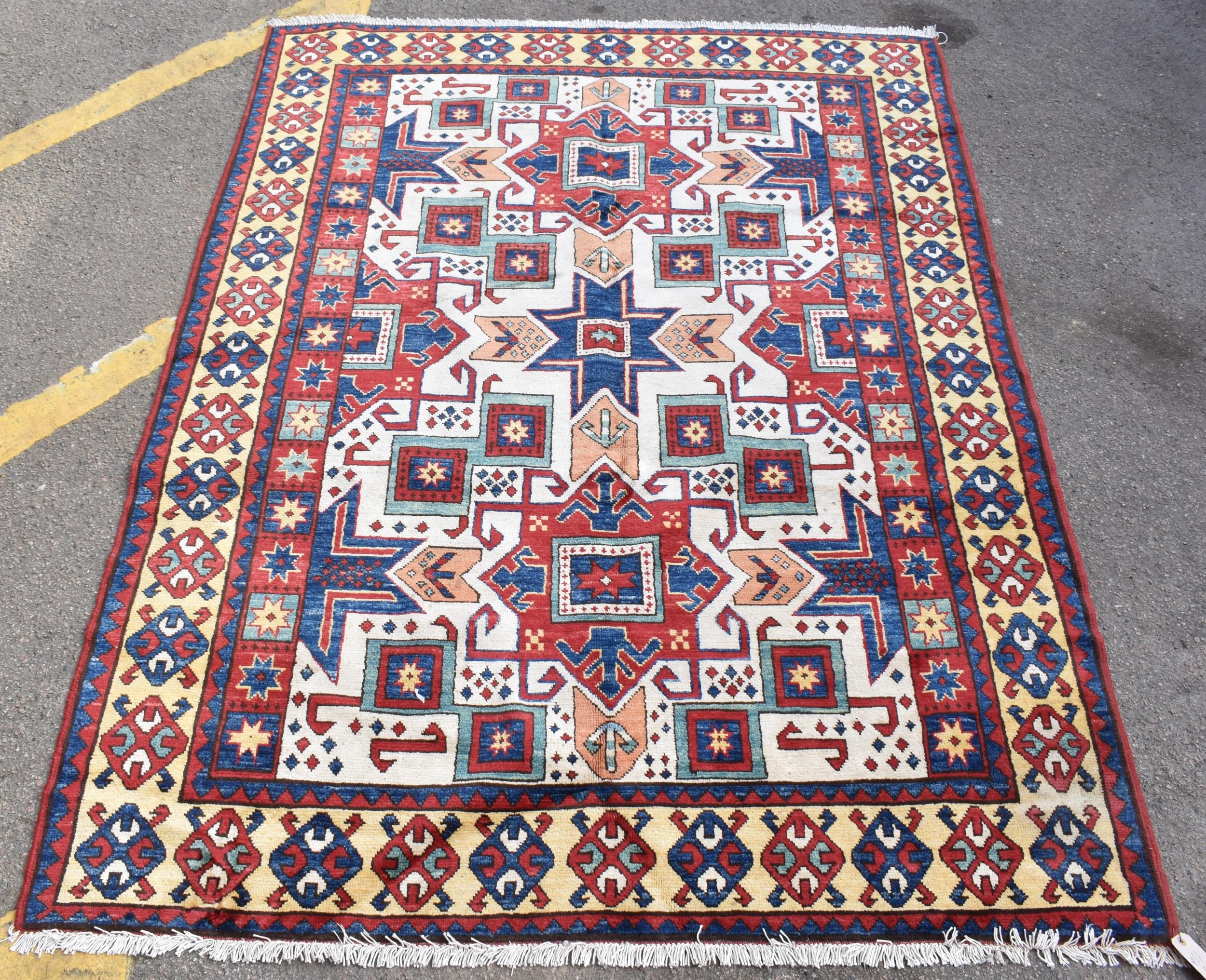 A handwoven Caucasian star kazak rug, having a geometric designs with repeating motifs, multiguard