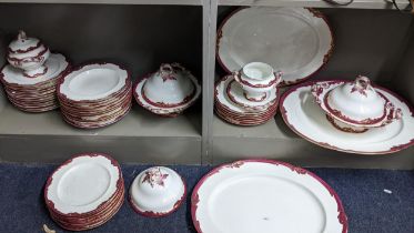 A Victorian porcelain part dinner service having a red painted border with gilt highlights Location: