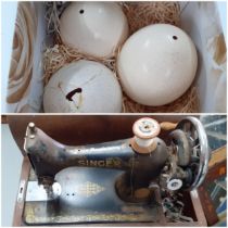 Three ostrich eggs A/F, together with an oak dome cased singer sewing machine, serial no Y8917673