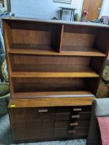 A mid-century retro teak side unit circa 1970, the top with open shelves, above a base with four