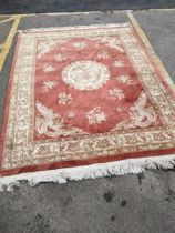 A group of three machine woven Chinese style rugs, the largest decorated with a dragon medallion