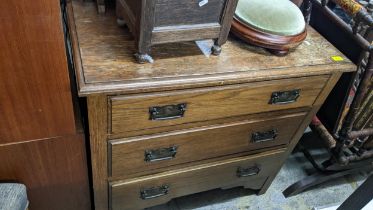 An oak chest of three drawers with extended back having single shelf, metal yin/yang handles, on