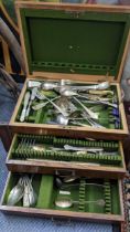 An early 20th century oak canteen of mixed cutlery including two silver teaspoons, salad servers and