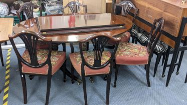 A reproduction mahogany D-end dining table with two extra leaves, together with a set of six