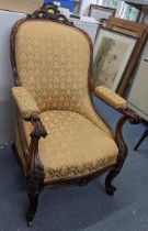 A Victorian rosewood salon armchair having scrolled arms with a serpentine front, cabriole front