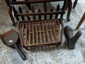 An iron fire grate with a shoe last and shovel Location: