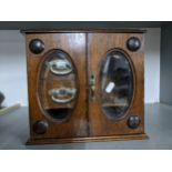 An early 20th century smokers/table top cabinet, twin glazed doors, internal drawers and open