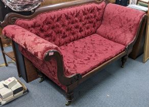 An early 20th century mahogany framed two seater settee upholstered on red floral fabric raised on