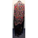 An early 20th century machine embroidered black Oriental shawl with vibrant images of roses, wild