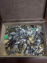 A wooden box containing a selection of vintage keys and a brass padlock Location:
