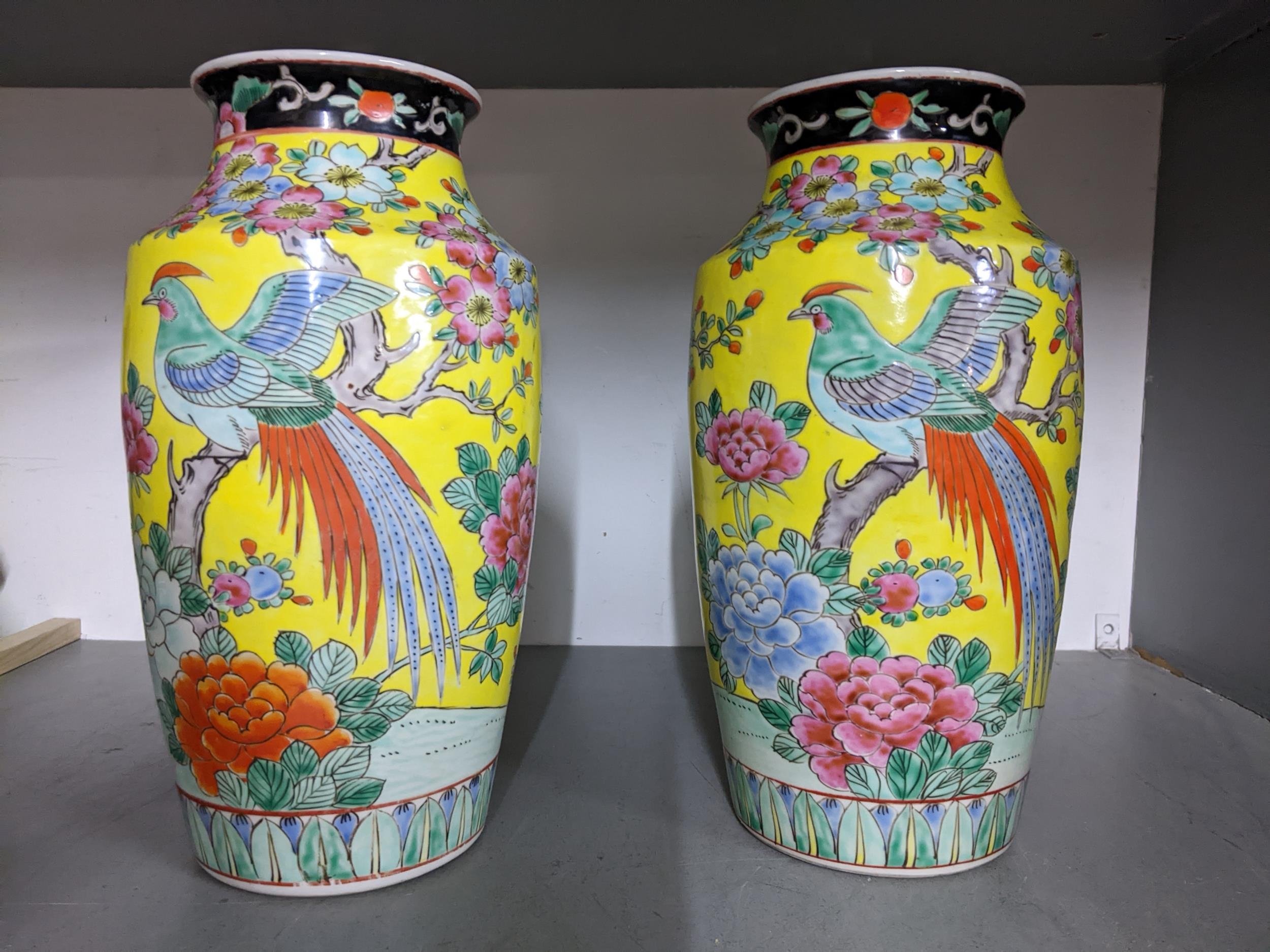 A pair of mid 20th century Chinese famille jaune porcelain vases decorated with a bird perched on