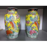 A pair of mid 20th century Chinese famille jaune porcelain vases decorated with a bird perched on