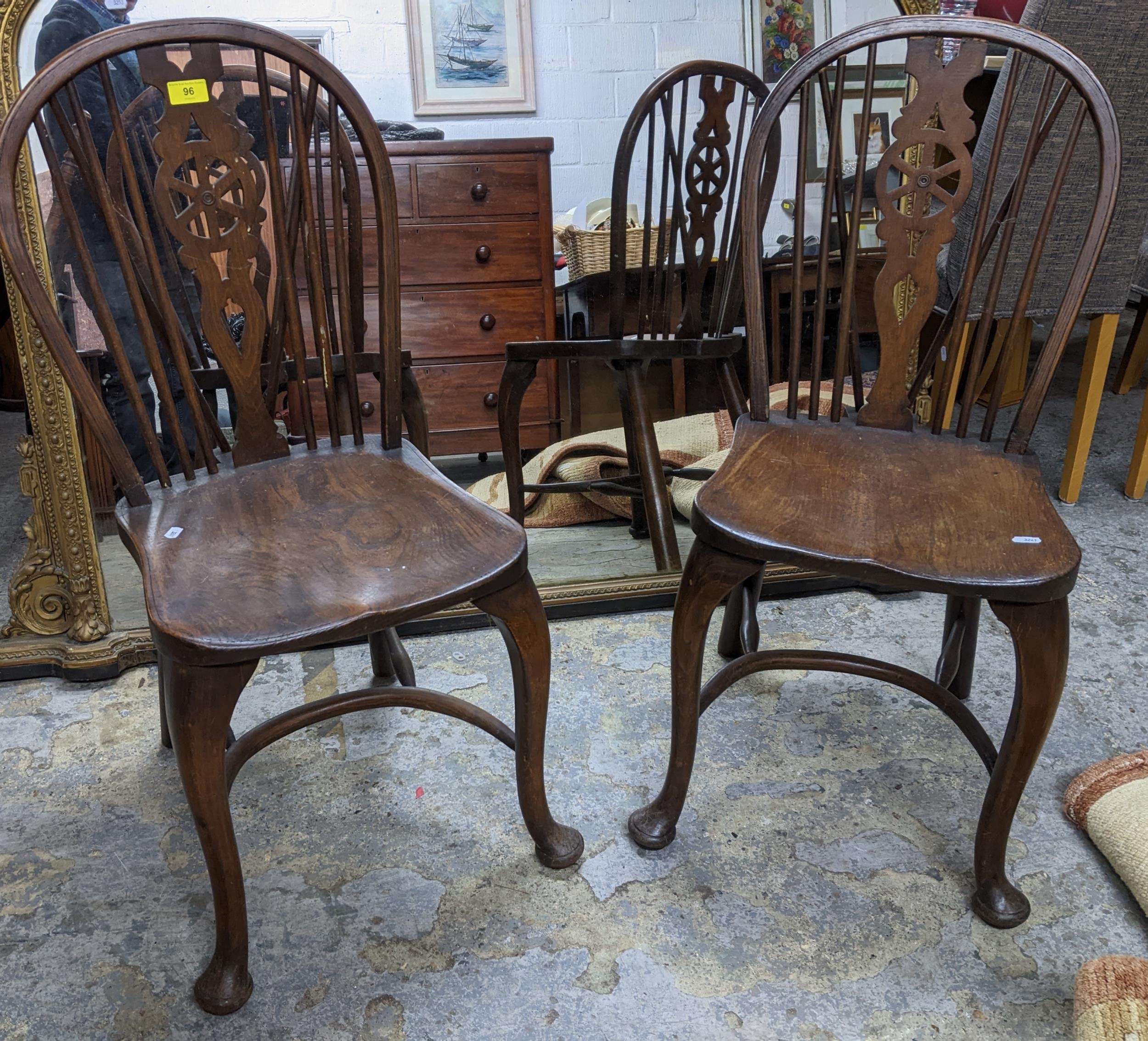 Two 20th century elm seated Windsor wheel back chairs with crinoline elliptical and stretchers,