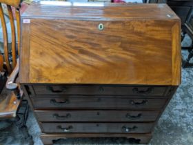 A Georgian mahogany bureau, fall flap revealing a pigeonhole and drawer interior, short drawer