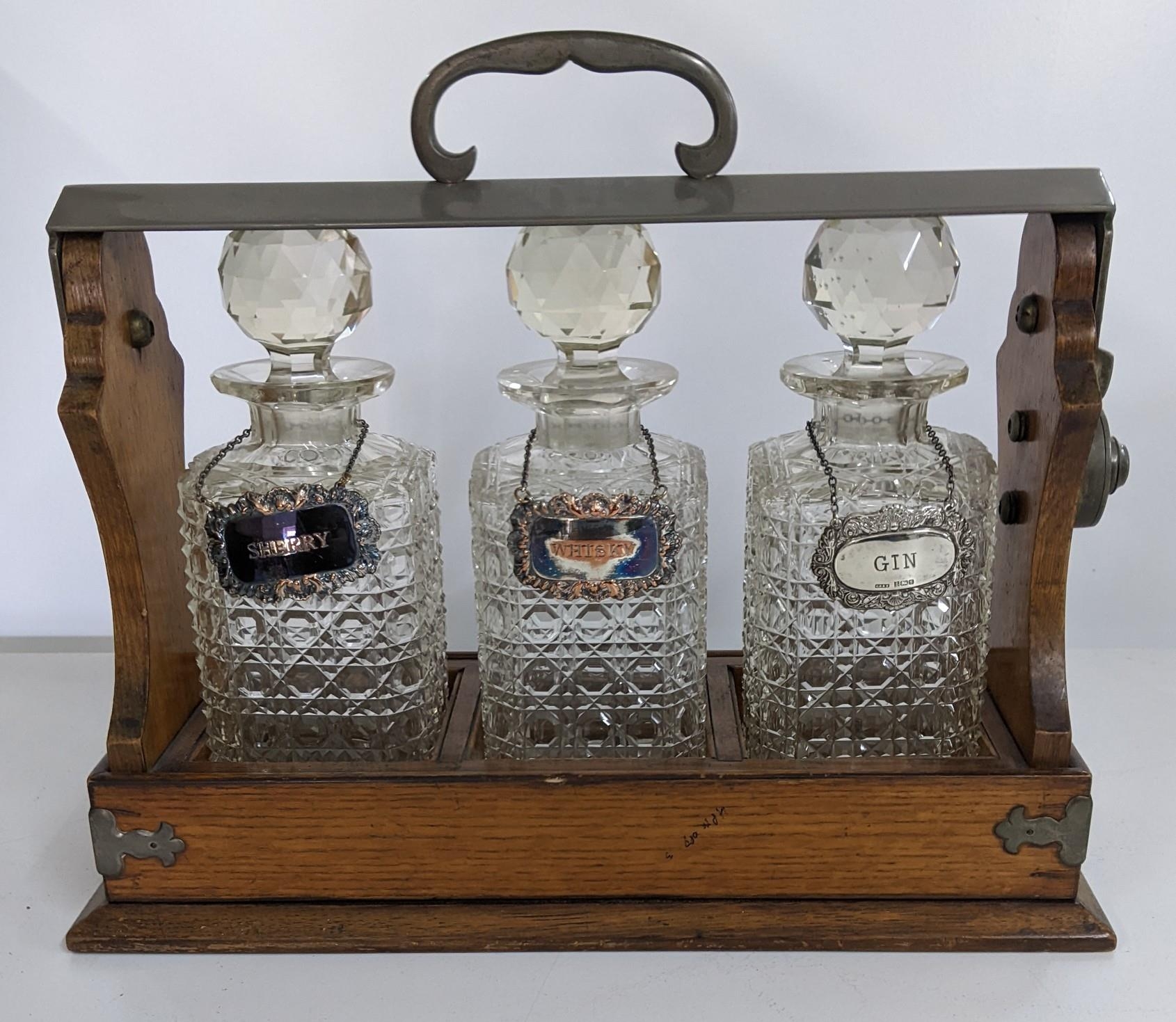 An early 20th century oak Tantalus with three decanters, no key Location: 1.5 - Image 2 of 2