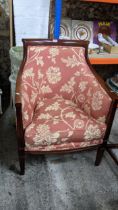 A reproduction mahogany upholstered armchair with loose cushion seat, on square tapering leg with