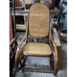 An early 20th century Thonet style bentwood and cane rocking chair, incised stamped '18' to base