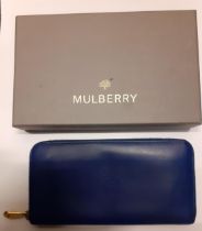 Mulberry- A mid blue leather purse having gold tone hardware and punched hole outline of the