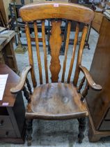 A late 19th century ash and elm Windsor armchair with shaped central splat, arms with out swept
