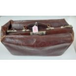 An early 20th Century brown leather Gladstone bag A/F having a crocodile design with brushed