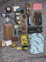 A mixed lot consisting of binoculars, lighters, a mid century desk calendar, a brass candle/