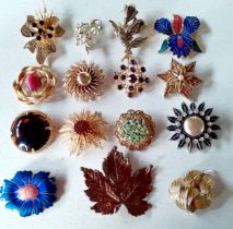 A group of vintage floral inspired gold tone brooches having various coloured cabochons and faux