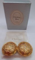 Christian Dior-A pair of monogrammed gold tone clip-on earrings in circular form with branded box.