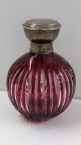 An early 20th century scent bottle having a silver top and flash ruby glass body Location: