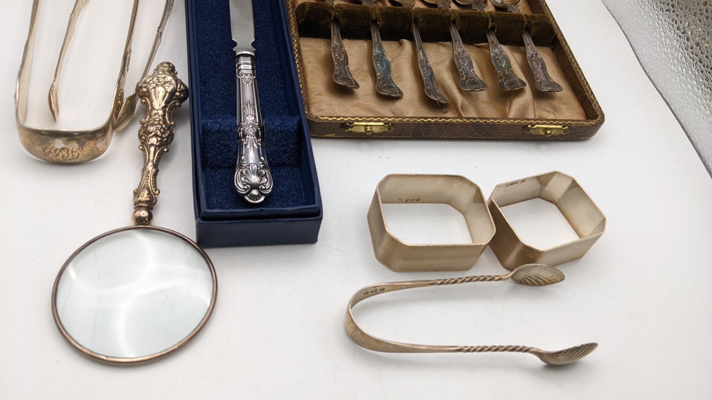 A group of mixed silver items to include three pairs of silver sugar tongs, a case set of silver tea - Image 3 of 3