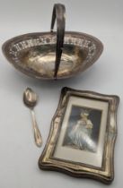 Mixed silver to include an embossed photo frame, a tea spoon and a white metal pierced oval shaped