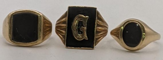 Three 9ct gold and black onyx gents signet rings to include one set with the letter G, size T,