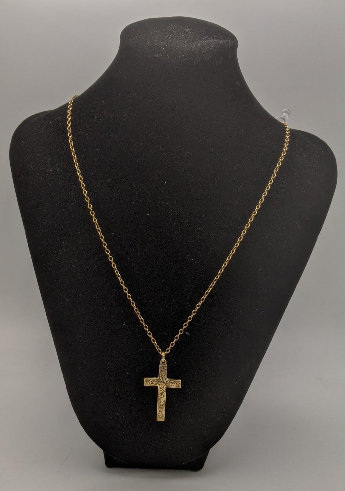 A 9ct gold cross pendant having a floral engraved design, on a gold necklace, tested as 9ct gold,