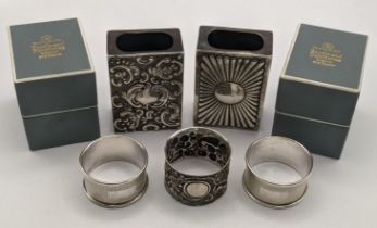 Two silver napkin rings, an embossed napkin ring and two matchbox covers, one having a floral