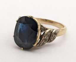 An 18ct gold ring inset with a sapphire in a claw setting and white sapphire shoulders Location: