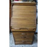 An early 20th century oak roll top desk, three graduated drawers below on bracket feet 112cm x
