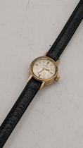 An Omega 1960s ladies 9ct gold manual wind wristwatch on a black leather strap, with a 9ct gold