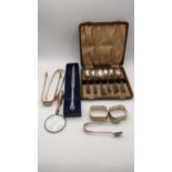 A group of mixed silver items to include three pairs of silver sugar tongs, a case set of silver tea