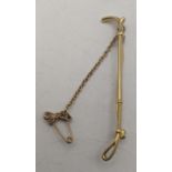 A gold coloured stick pin fashioned as a riding crop 4.7g, tested as 18ct gold Location: