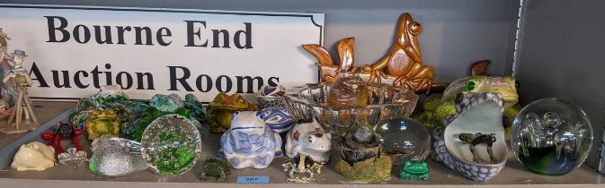 A collection of ceramic, china and glass model frogs, together with glass paperweights and a cut