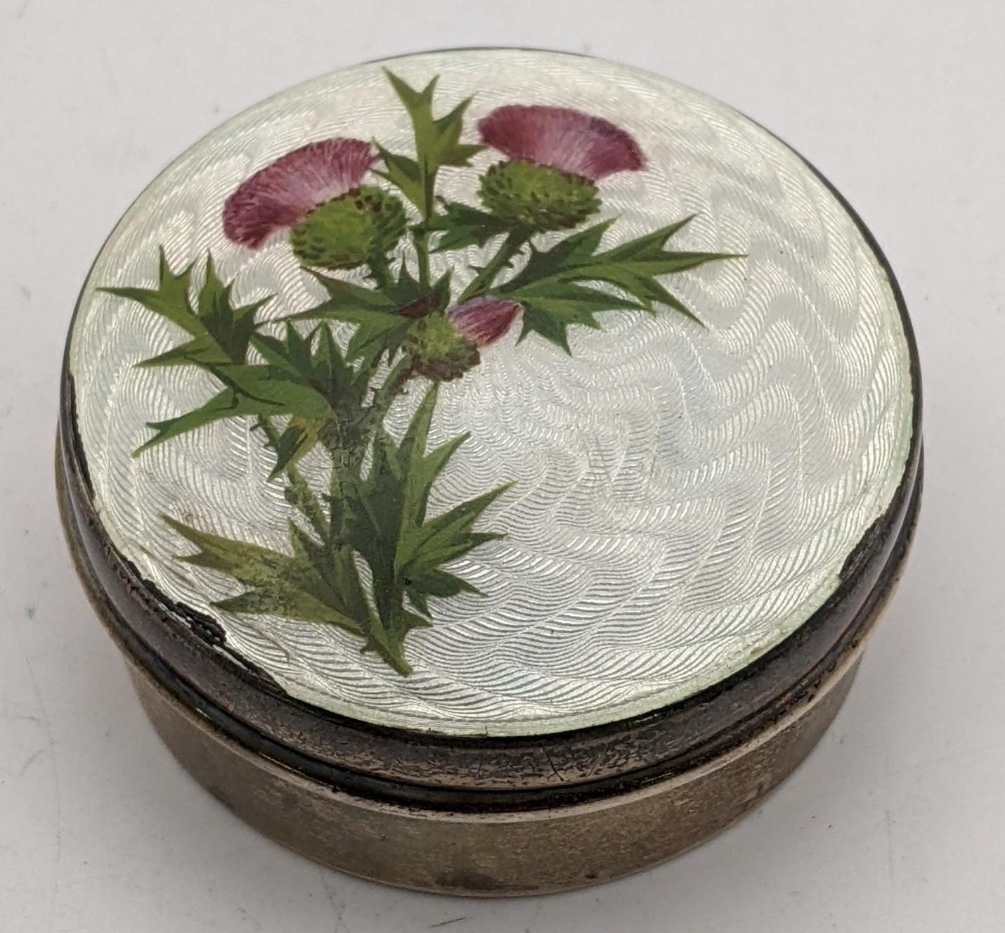 An Edwardian silver and enamelled circular pill box, decorated with thistles to the lid 36.2g