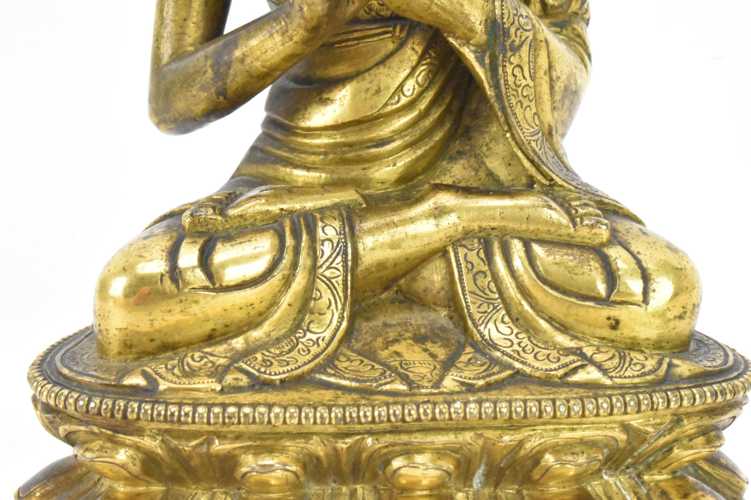 A Sino Tibetian gilt bronze figure of Buddha, 18th/19th century, dressed in monastic robe, with - Image 8 of 16