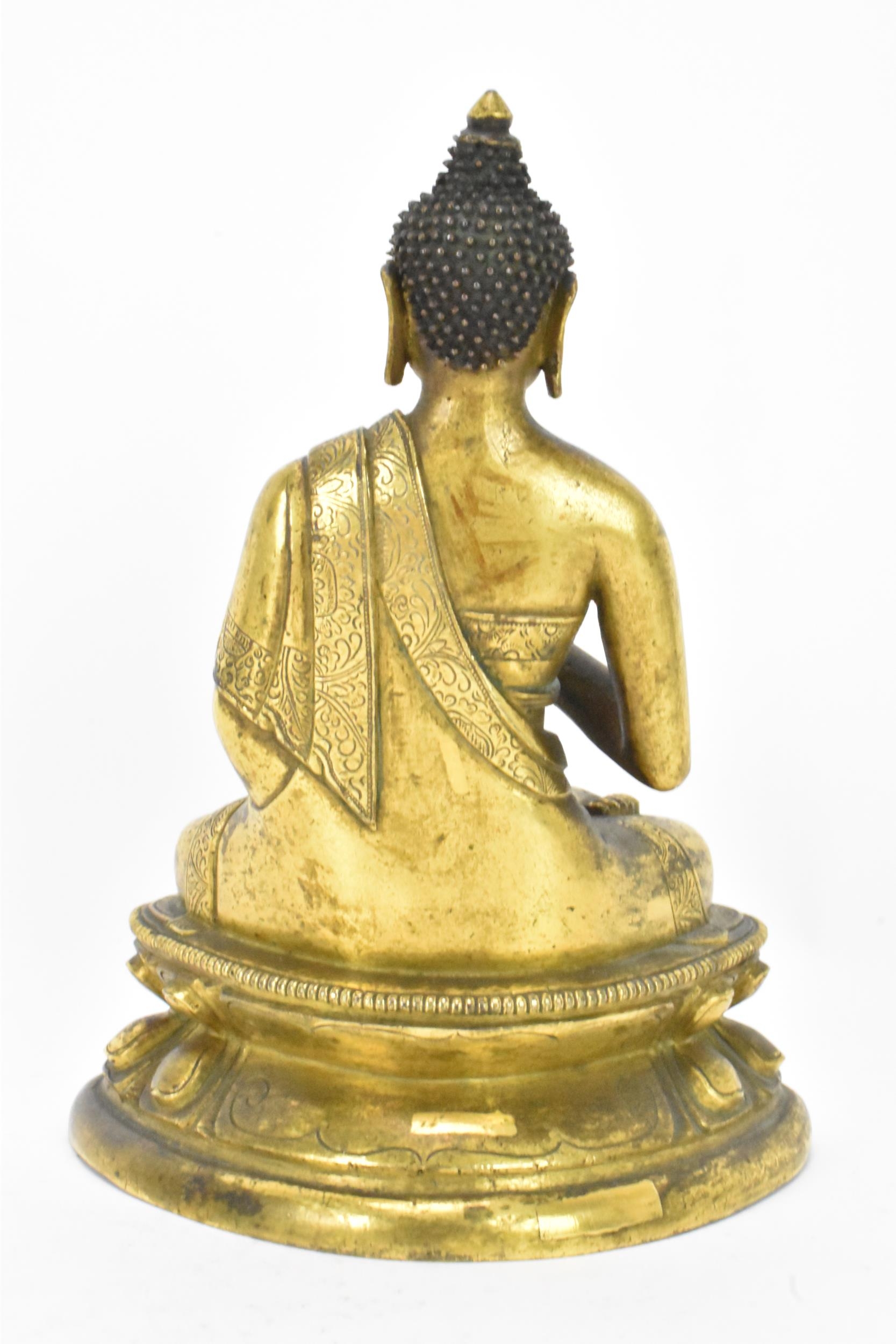 A Sino Tibetian gilt bronze figure of Buddha, 18th/19th century, dressed in monastic robe, with - Image 3 of 16