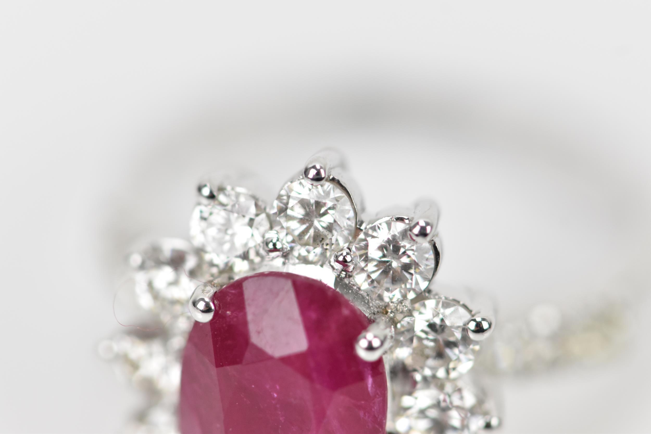 An 18ct white gold, diamond and ruby dress ring, set with central oval mixed cut ruby in four claw - Bild 4 aus 12