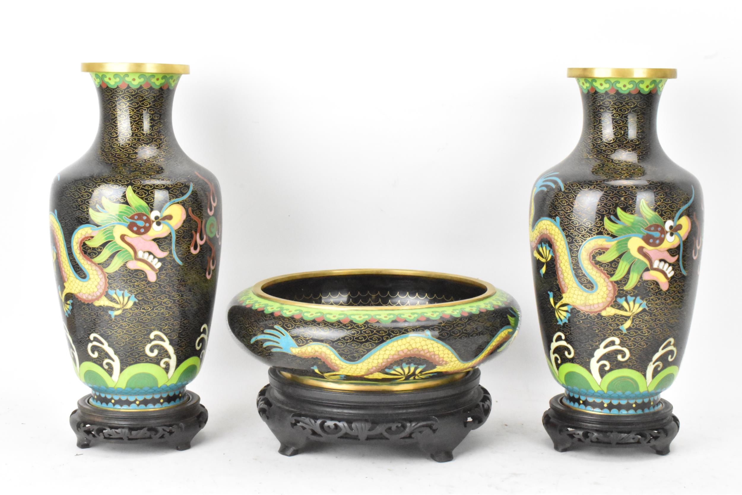 A pair of Chinese mid 20th century cloisonne vases and a bowl, all with black grounds decorated with