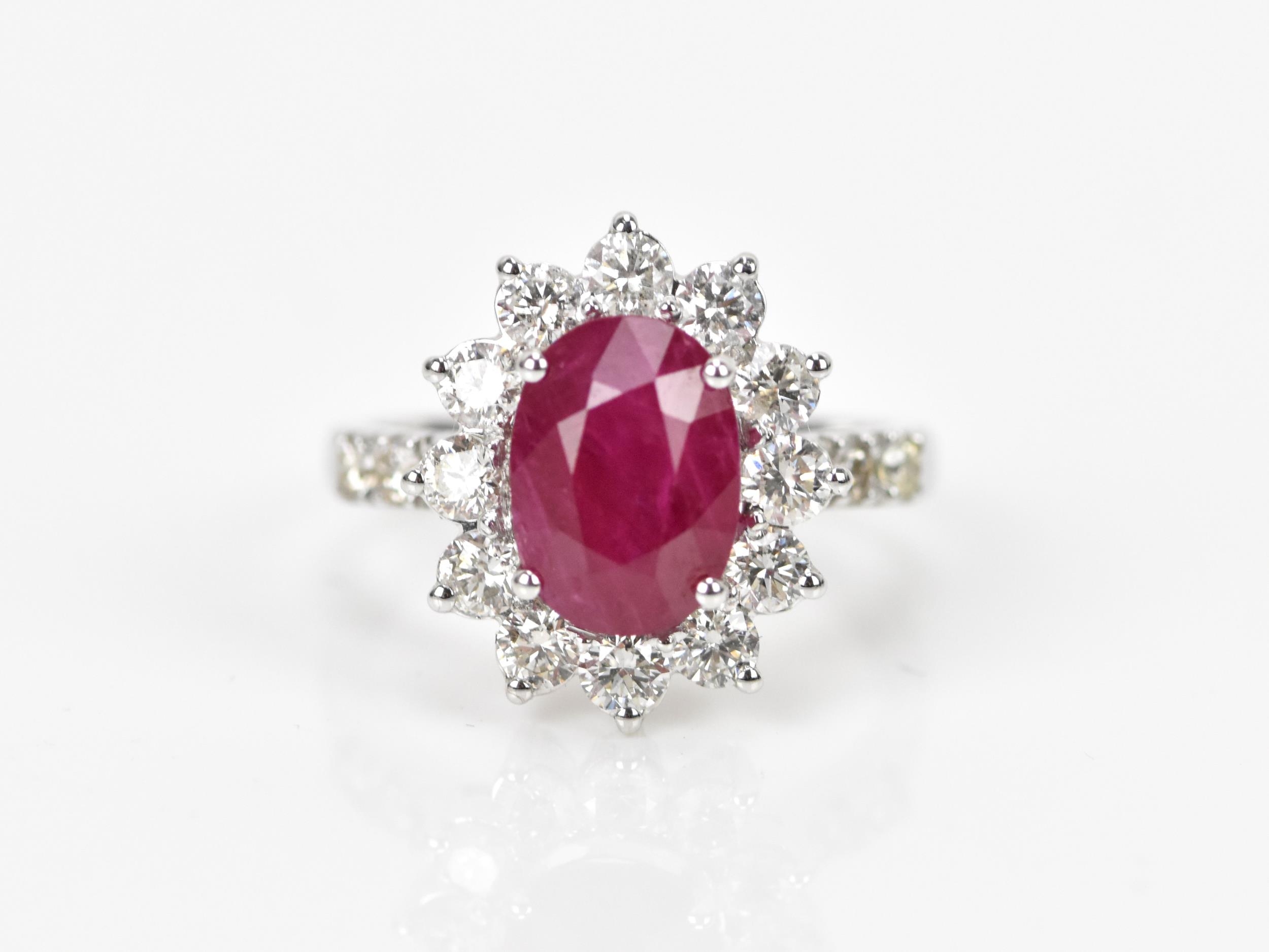 An 18ct white gold, diamond and ruby dress ring, set with central oval mixed cut ruby in four claw