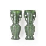 A pair of Chinese 20th century jadeite vases, of flattened baluster shape with archaistic relief