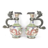A pair of Chinese late Qing dynasty cloisonne ewers, both having a handle modelled in the form of