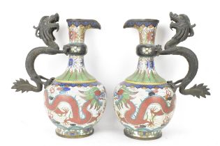 A pair of Chinese late Qing dynasty cloisonne ewers, both having a handle modelled in the form of