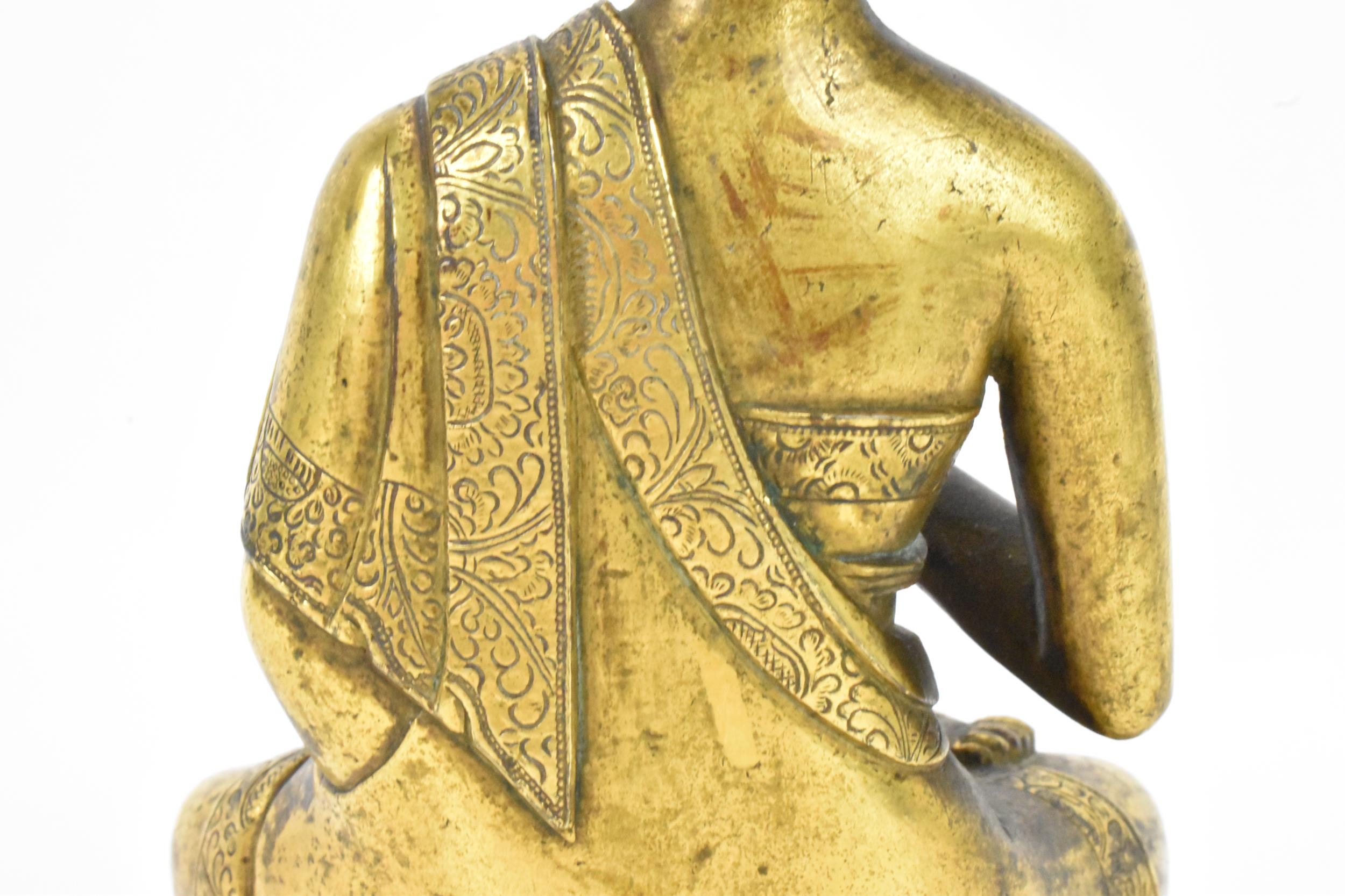 A Sino Tibetian gilt bronze figure of Buddha, 18th/19th century, dressed in monastic robe, with - Image 11 of 16